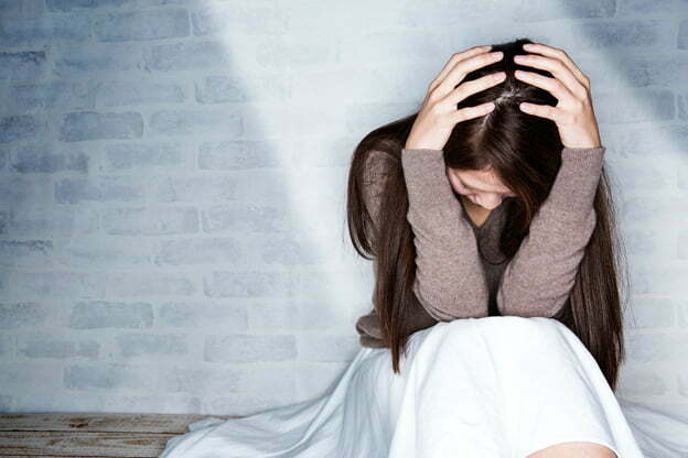 A woman holding her head in depression