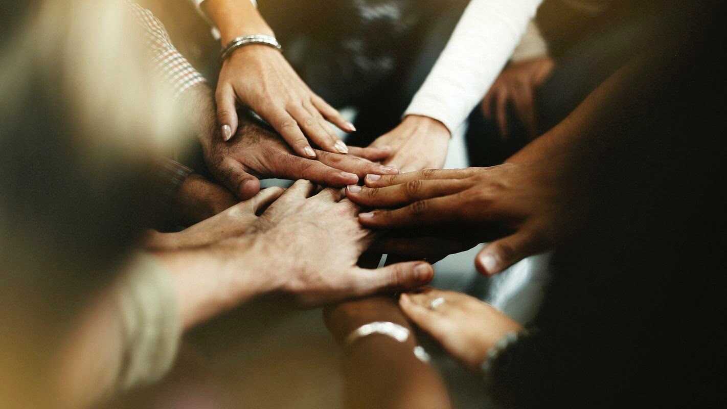 Group of people touching hands in a circle