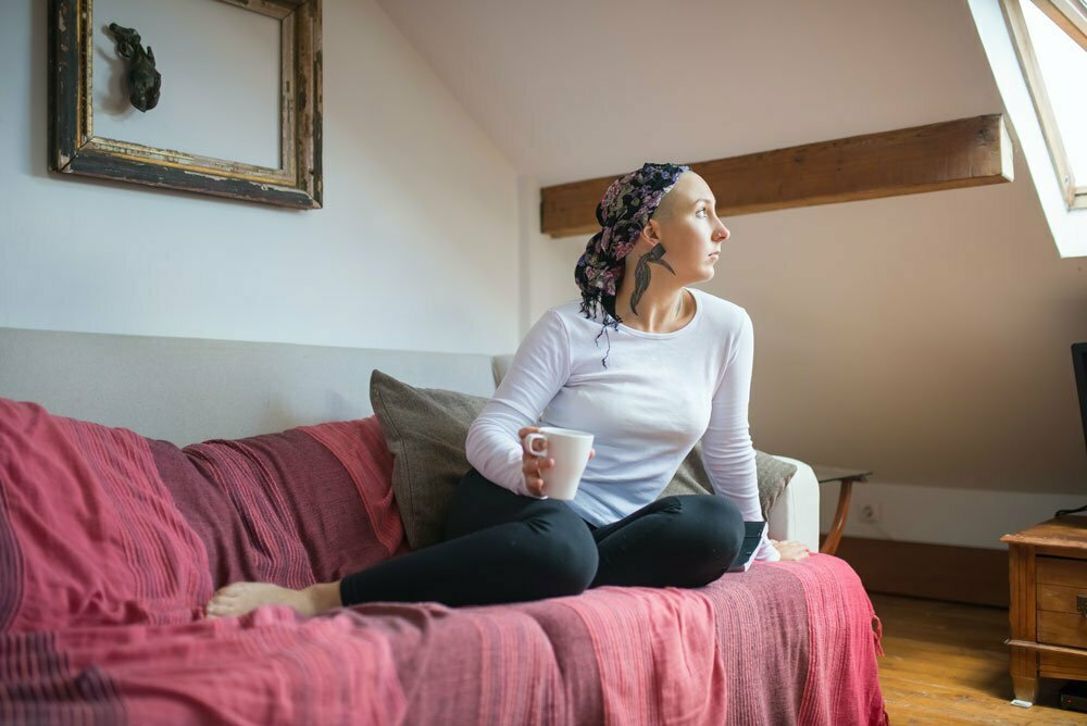 Woman looking out sitting on bed