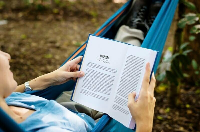 a person reading a book in a hammoc in hawaii