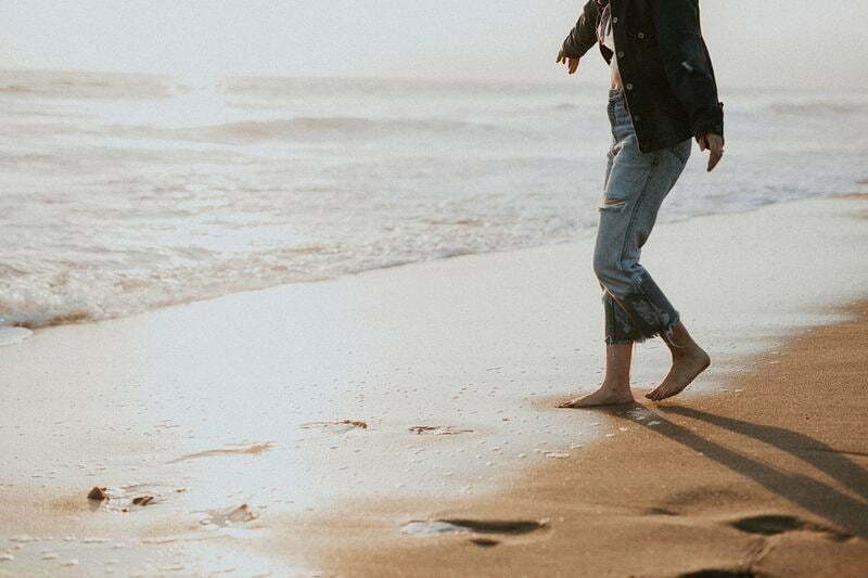 Woman on beach with footprints