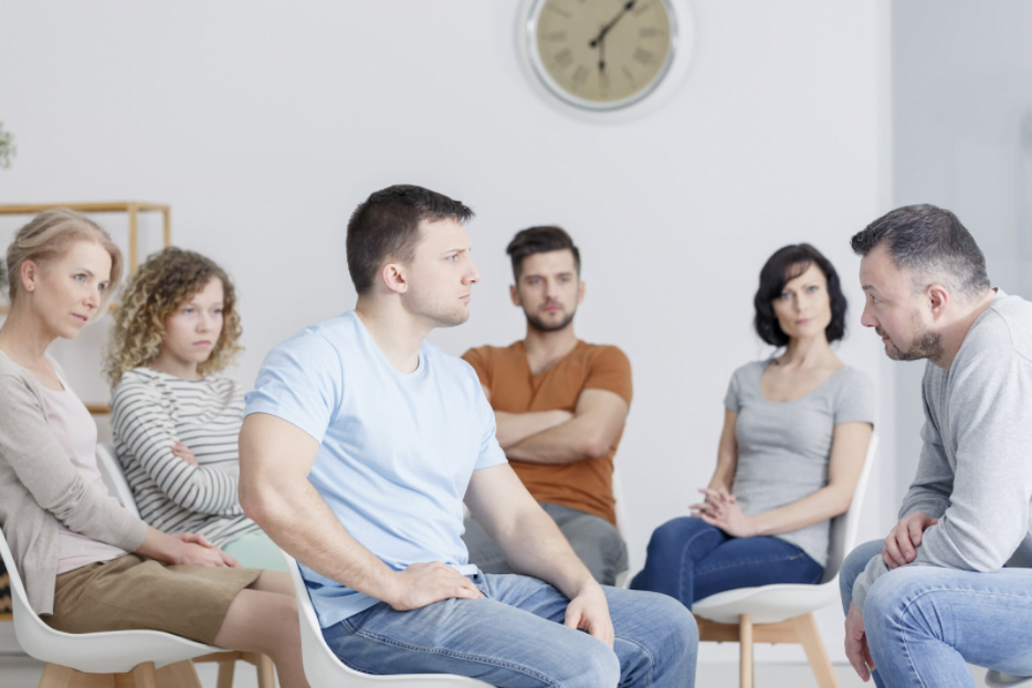 A group of people discussing addiction treatment